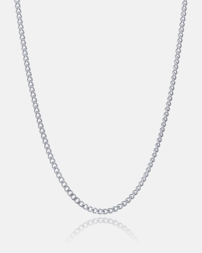 The 2.3mm Curb Chain is a simple, thin necklace with small, evenly spaced links for a classic, refined look. Displayed on a white background, the chain forms a gentle curve at the bottom.