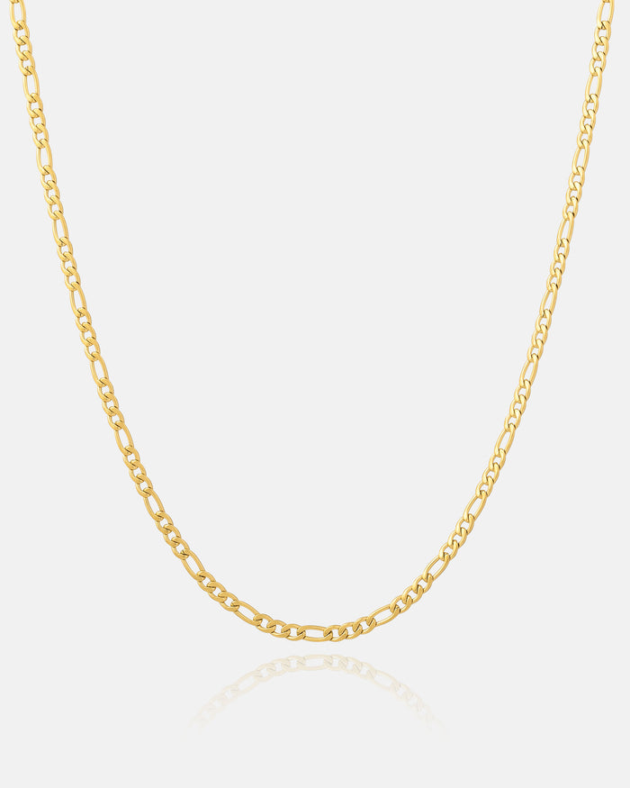 The 2.9mm Figaro Chain (Gold) is showcased on a white background, its slender gold links forming a gentle curve with a subtle reflection underneath.