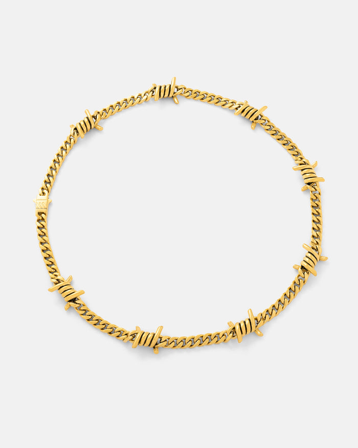 The 6mm Barbed Wire Cuban Chain (Gold) features evenly spaced, twisted barbed accents on an 18k gold-plated chain—displayed against a white background, this bold statement piece is part of the Echoes collection.