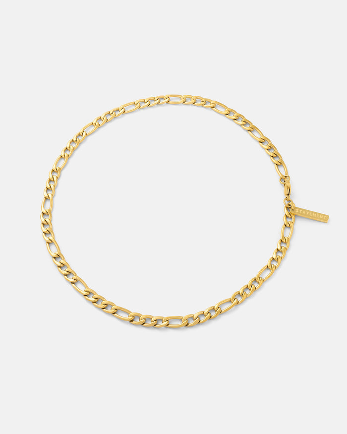 Thick gold Figaro chain necklace on white background