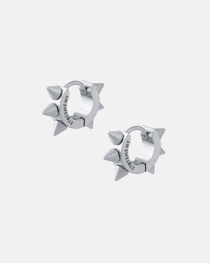 A pair of 6mm Spiked Hoop Earrings (Gold), each with three evenly spaced pointed spikes and "STATEMENT" engraved on the inner edge, displayed against a plain light gray background.