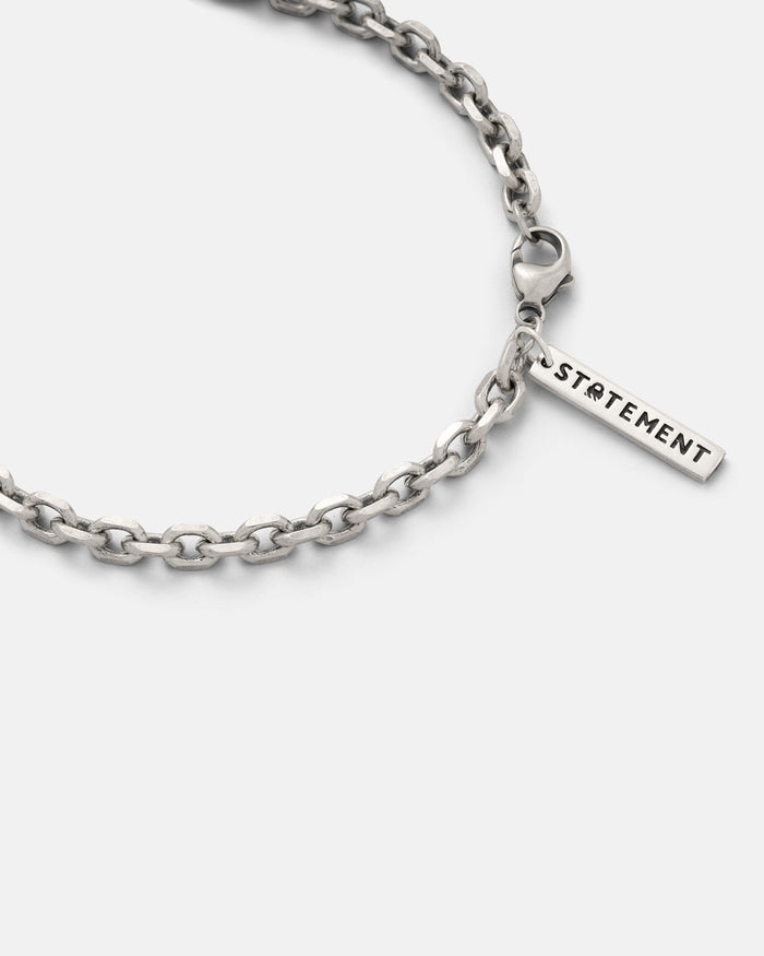 Close-up of a 925 Sterling Silver 4.5mm Cable Chain necklace with a lobster clasp and a rectangular charm engraved “STATEMENT” on a plain white background.