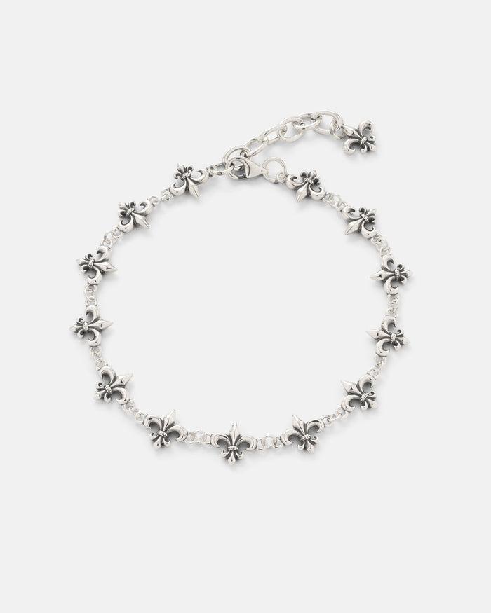 The Statement Collective 925 Sterling Silver "Fleur De Lis" 10mm Bracelet showcases a chain of small, evenly spaced fleur-de-lis charms and features an adjustable clasp, beautifully presented on a plain white background.