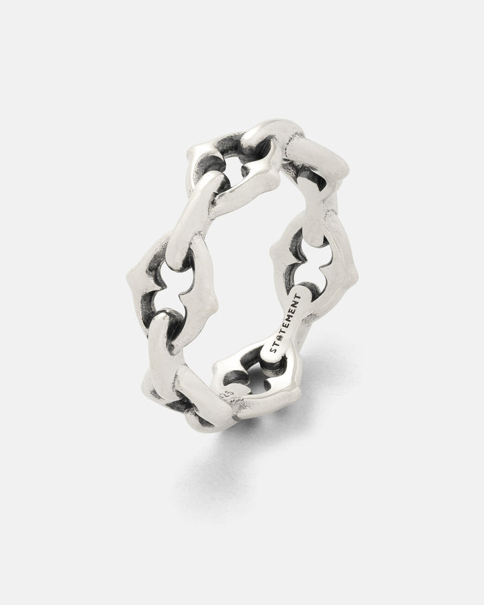 A 925 sterling silver “The Cathedral” Spiked Ring by Statement Collective, featuring an interlocking geometric chain link band design with a matte finish, displayed on a plain white background. The inside of the ring is engraved with text.