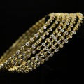 Gold bracelet with clear stones on a dark background, featuring the brand 'Saheli'.