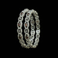 Silver bangles with gemstones on a black background, featuring the brand 'Saheli'.