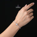 Silver bracelet with a clasp on a dark background, featuring the 'SAHELI' brand.