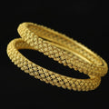 Gold bangles on a black velvet stand with 'SAHELLI' branding.