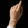 Gold bracelet with clear stones on a black background