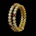 Gold and diamond bracelet with red stones on a dark background, branded 'SAHELI'.