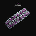 Decorative headband with pink and silver design on a black background, featuring the brand 'SAHELI'.