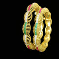 Gold bangles with green and red stones on a gray background, featuring the brand 'Saheli'.