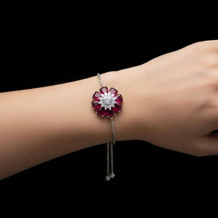 Silver bracelet with red and white gemstones on a gray background, branded 'SAHELLI'.