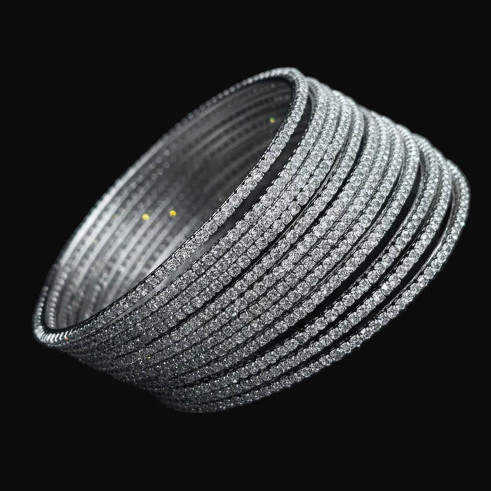 Set of silver bangles on a black cushion with 'SAHELI' branding.