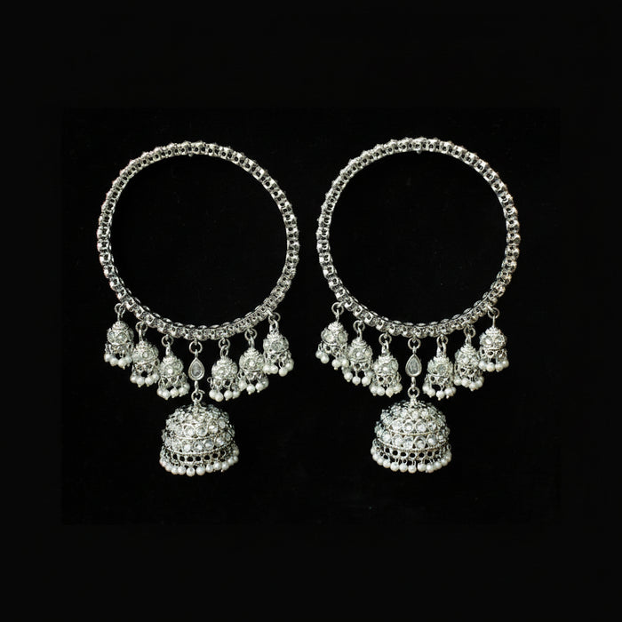 Pair of silver hoop earrings with dangling beads on a black background