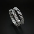 Two diamond bracelets on a gray cushion against a dark background