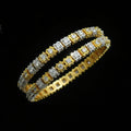 Gold and silver bracelet on a black stand with 'SAHELI' branding.