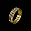 Gold bracelet on a gray stone surface with a dark background