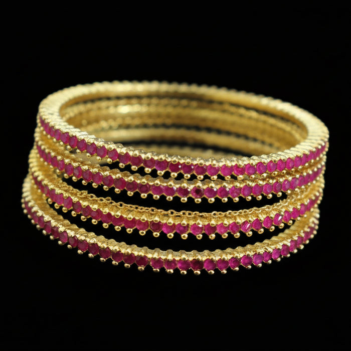Set of gold and red bangles on a mannequin with 'SAHELI' branding.