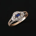 Elegant bracelet with floral design and blue gemstone on a wrist against a black background