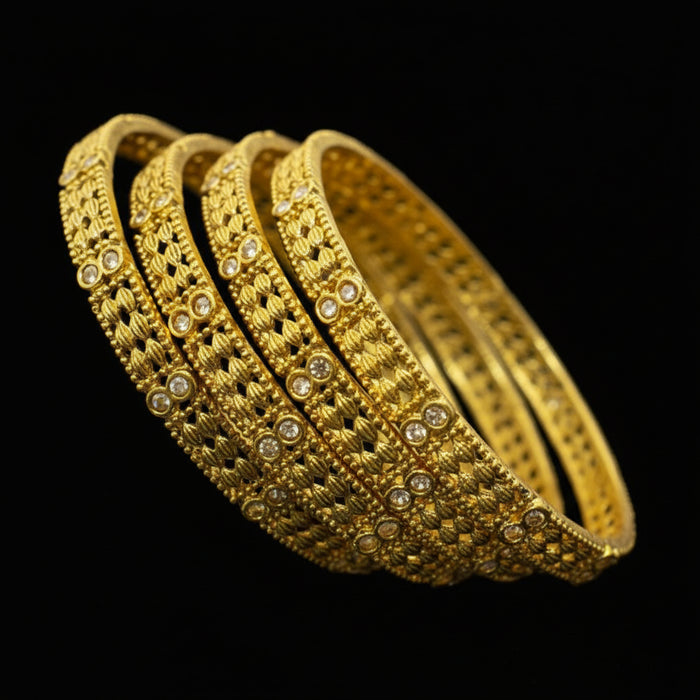 Set of gold bangles with 'Saheli' branding on a dark background