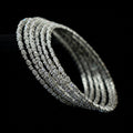 Silver bracelet with multiple rows of diamonds on a dark background, branded 'Saheli'.