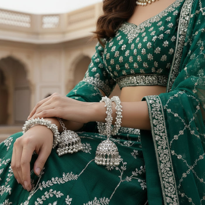 Silver earrings with intricate designs on a black background, featuring the brand 'Saheli'.