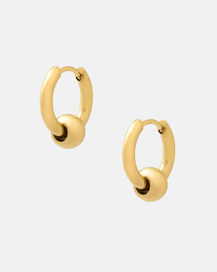 Ball Hoop Earrings (Gold), featuring 18k gold plating and a small gold sphere on each hoop, are hypoallergenic—ideal for sensitive ears. Shown against a plain white background.