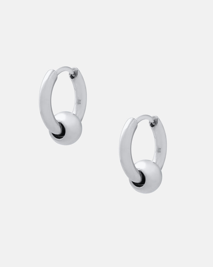 The Ball Hoop Earrings are small, hypoallergenic stainless steel hoops, each with a smooth silver bead at the center, shown on a plain white background.