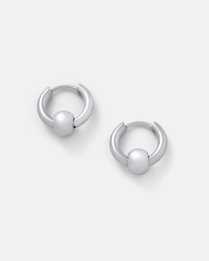 Ball Hoop Earrings: Small, silver hoops with smooth bead accents, crafted from hypoallergenic stainless steel, shown on a plain light gray background.