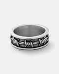 The Statement Collective Barbed Wire Ring showcases a raised barbed wire design encircling its 316L stainless steel band, displayed on a plain white background.