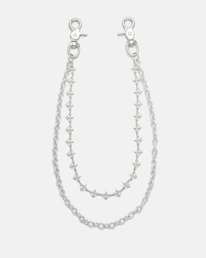 Introducing the “Baroque” Fleur De Lis Wallet Chain by Statement Collective: this set features two sterling silver chains, each fitted with clasp hooks at both ends and designed with star-shaped links accented by delicate fleur de lis motifs. The chains come in slightly different lengths to create a layered effect, beautifully displayed against a plain white background.