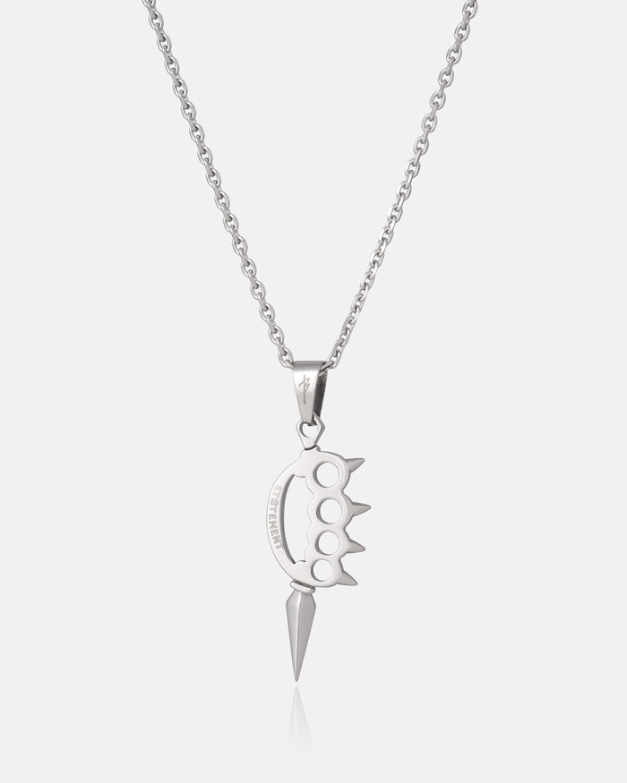 Silver necklace with a knuckle duster design hanging on a white background