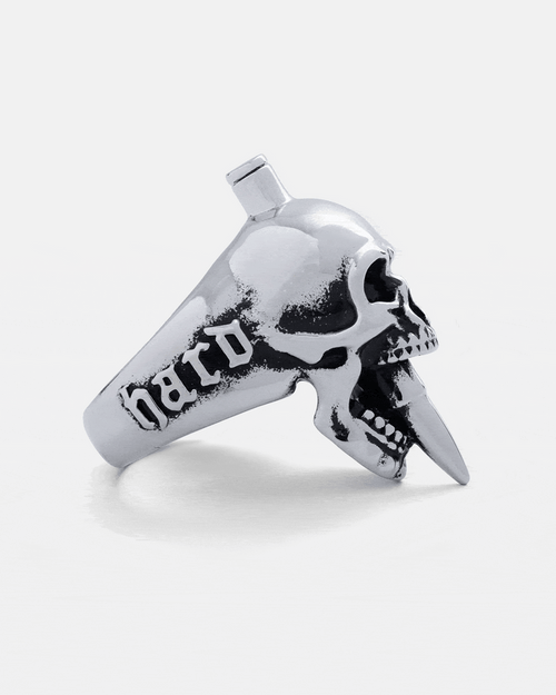 The "Bite The Bullet" Ring by Statement Collective is a silver skull ring with a spike through its mouth and "hard" engraved on the band—ideal for fans of bold rock jewellery.