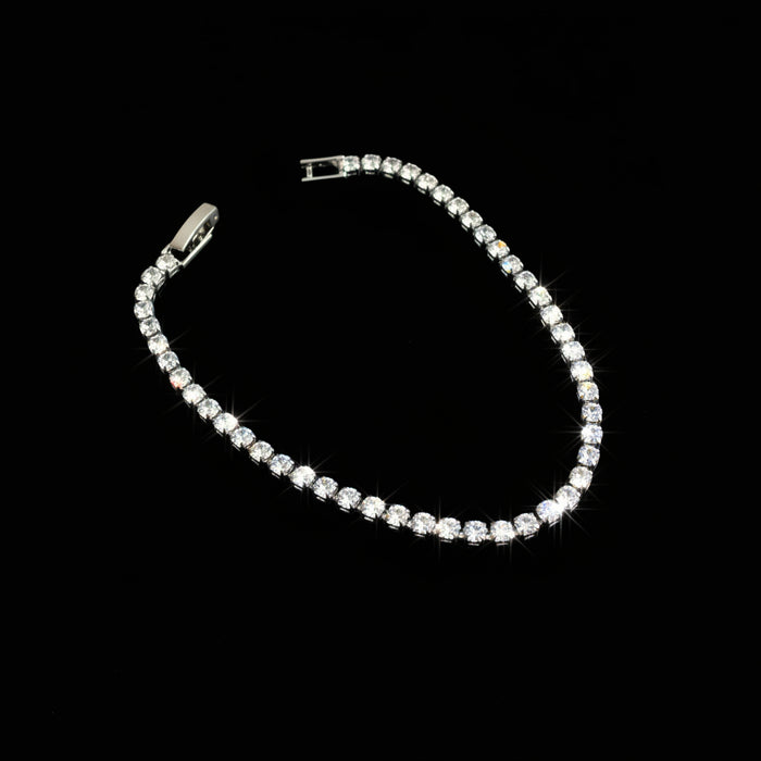Silver bracelet with clear stones on a black background