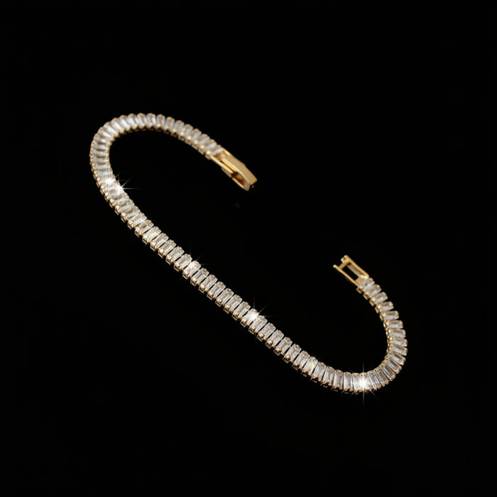 Gold bracelet with diamond accents on a dark reflective surface