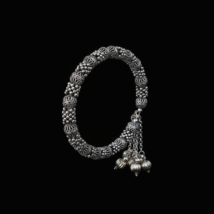 Silver bangles with jhumkas on a black background, featuring the brand 'Saheli'.