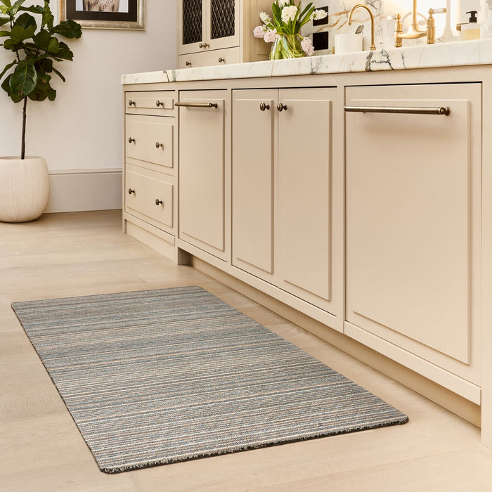 Candy Sand Striped Washable Runner- a 100% recycled material runner featuring a subtle striped pattern in shades of teal, beige, brown, white, and light grey.