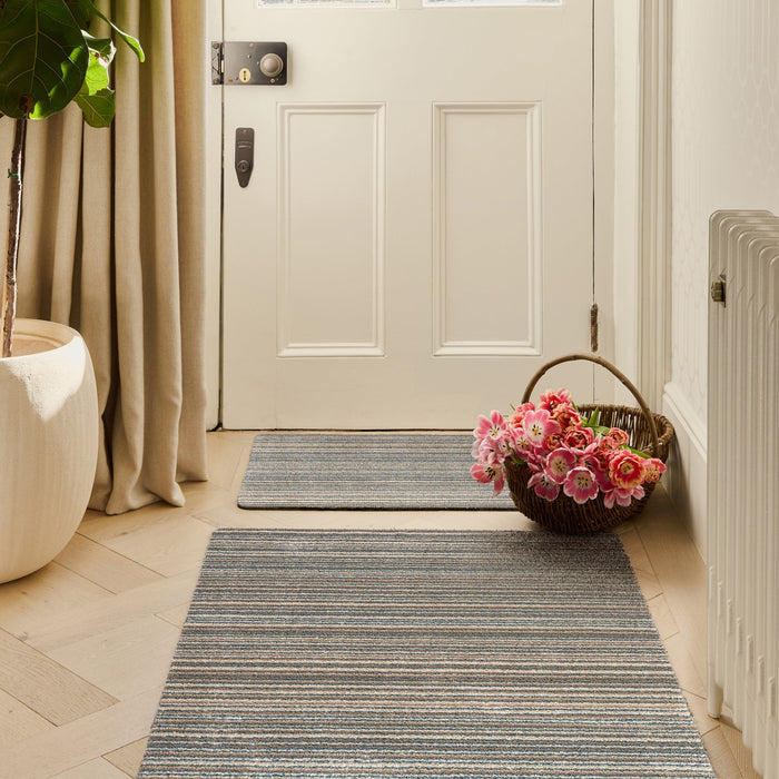 Candy Sand Striped Washable Runner- a 100% recycled material runner featuring a subtle striped pattern in shades of teal, beige, brown, white, and light grey.