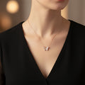 Rose gold necklace with a butterfly pendant on a white card with 'A.B.N.' branding against a black background.