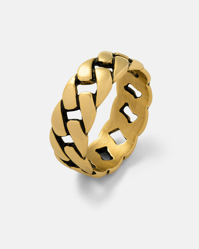 Statement Collective Cuban Link Ring (Gold) features a bold, chunky chain-link design with striking black accents between the links and a polished finish, showcased against a plain light background.