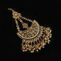 Gold necklace with floral designs on a dark background, featuring the brand 'Saheli'.