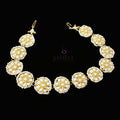 Gold and pearl necklace with matching earrings on a dark background, featuring the brand 'Saheli'.