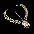 Delicate necklace with floral design on a dark background, featuring the brand 'Saheli'.