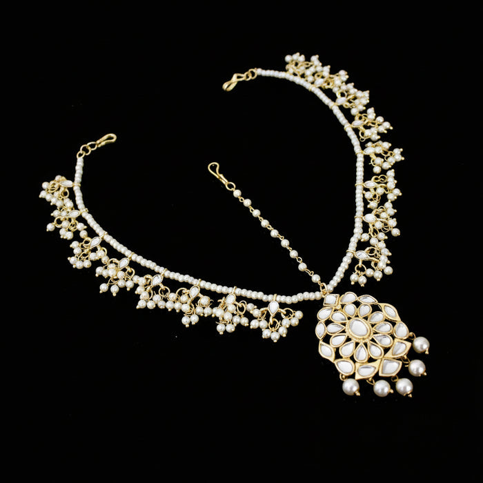 Delicate necklace with floral design on a dark background, featuring the brand 'Saheli'.