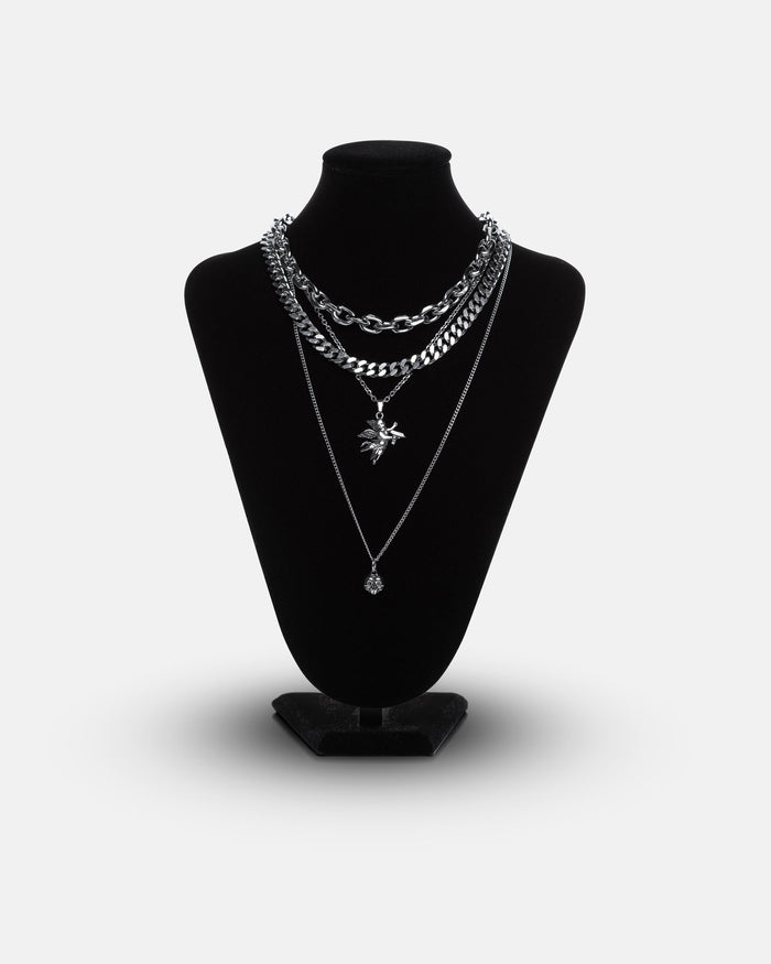 A black mannequin displays the Statement Collective Dead Love Set, a grunge necklace set featuring layered chains and pendants—including a striking skull heart pendant—against a plain white background.