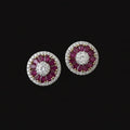 Pair of pink gemstone earrings on a gray stand with 'Saheli' branding.