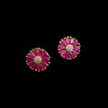 Pair of pink flower-shaped earrings with gold accents on a gray background with 'SAHELI' branding.
