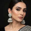 Pair of silver and pearl earrings on a black stand