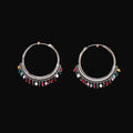 Pair of silver hoop earrings with colorful beads on a brown background